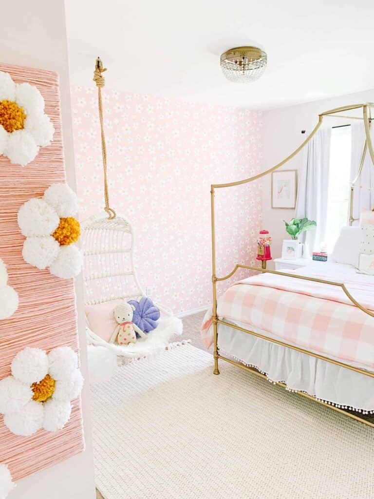 Girls room with DIY daisy wall art, dairy wallpaper, and pink and white plaid bedding.