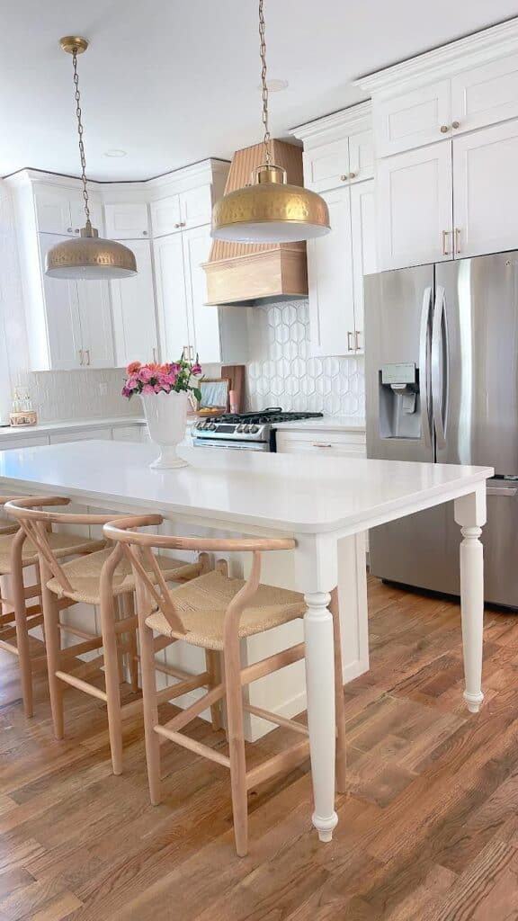 White kitchen island with a vase of flowers.