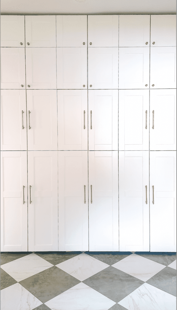 Floor to ceiling white mudroom lockers.