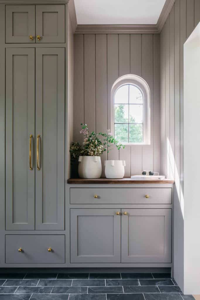 Rectangular stone tile in navy is showcased in this farmhouse mudroom.