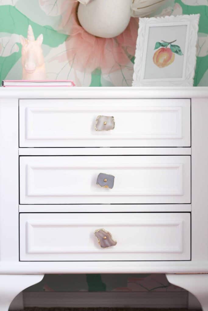 Switch Out Hardware For Custom Look In Toddler Girl Bedroom On A Budget as seen in this white nightstand with stone hardware.