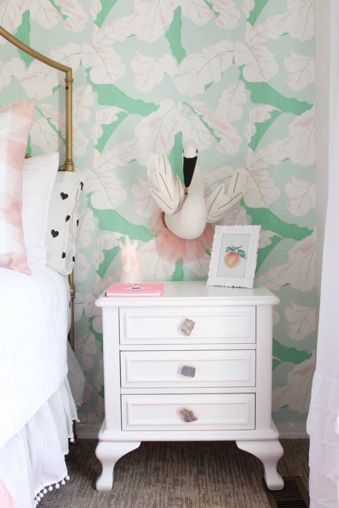 Toddler girl bedroom ideas on a budget can include reusing furniture and switching out hardware as seen in this white nightstand with stone hardware.