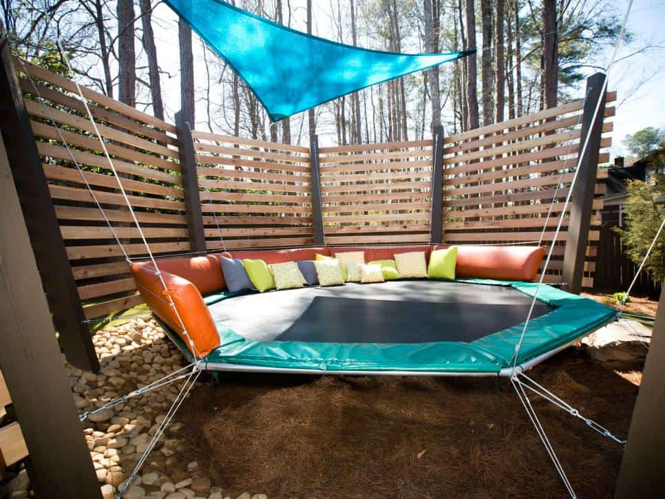 Backyard trampoline ideas include this hanging trampoline with pillows.