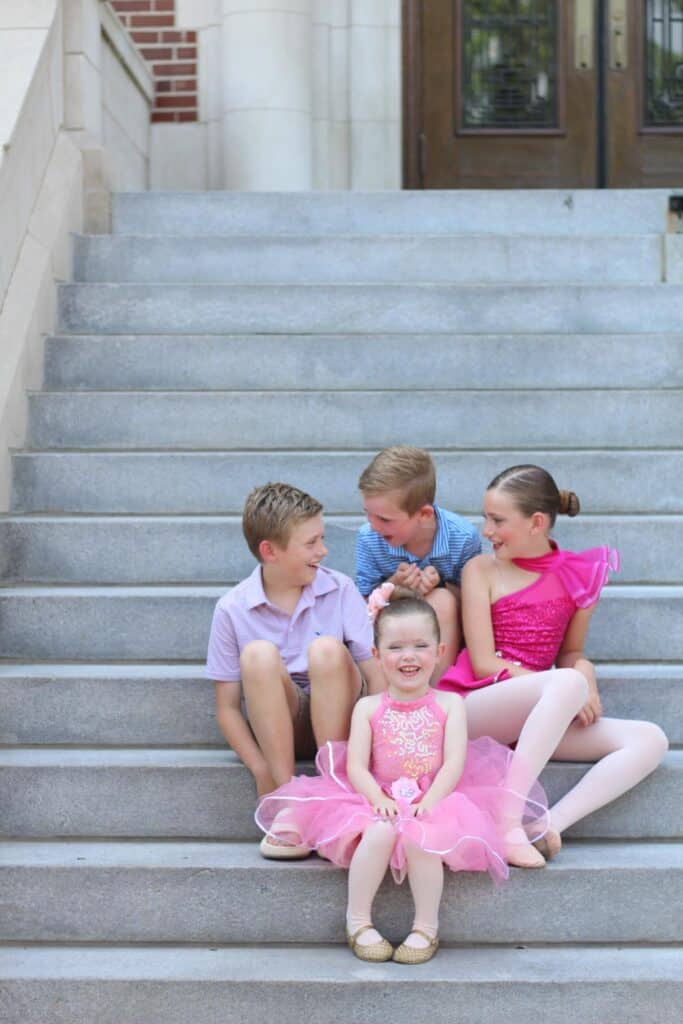 Four kids sitting on stair steps.