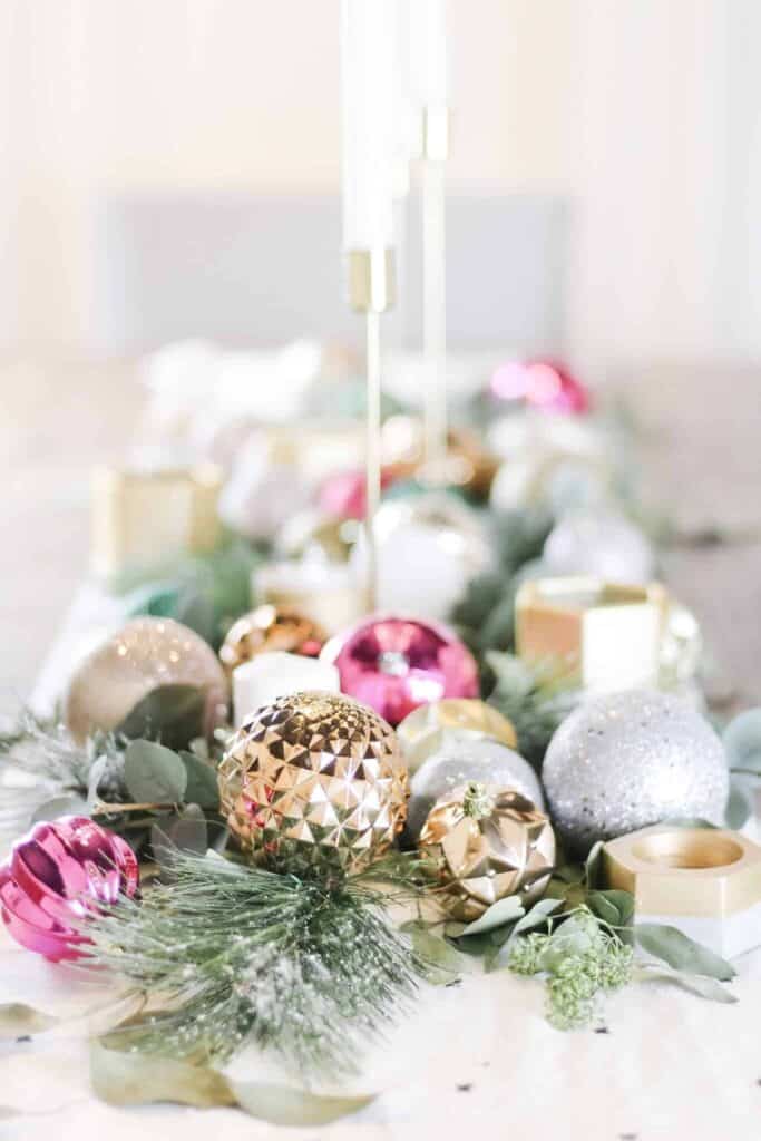 Christmas inspired everyday table centerpiece ideas with greenery, candlesticks, and ornaments.
