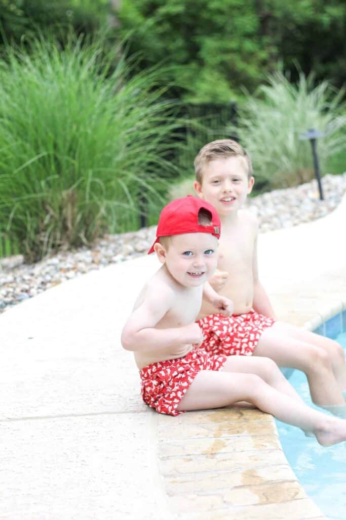 Little boys sitting poolside for 4th of july pool party ideas