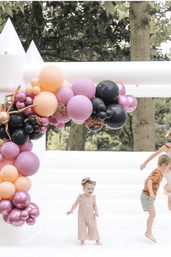 kids bouncing on a white bounce house.