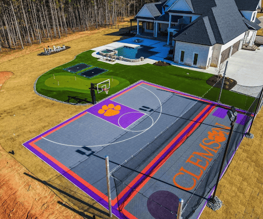 Backyard trampoline ideas includes a full gaming. court, putting green, pool, and trampoline for the ultimate backyard.