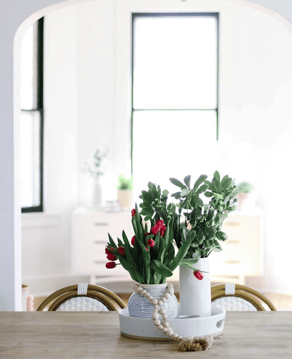 Everyday table centerpiece ideas with a rounded tray, vases, and fresh florals.