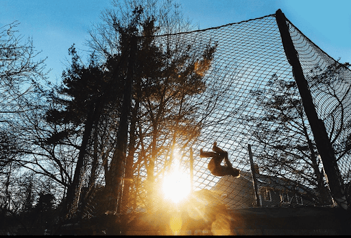 This backyard trampoline showcases an impressive flip at sunset.