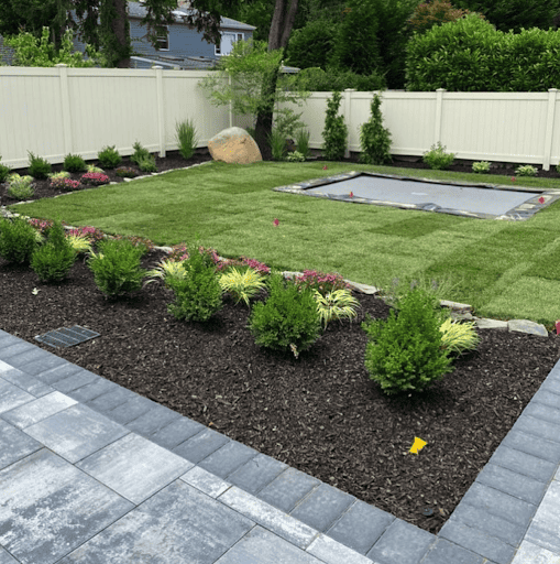 Backyard trampoline ideas include landscaping around the trampoline with bushes for privacy.