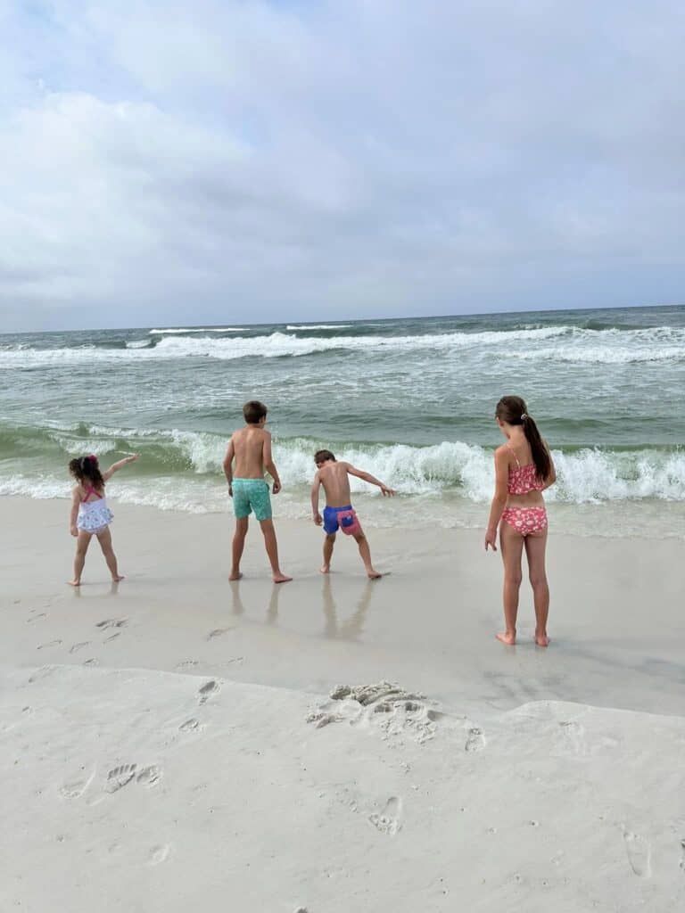 Four kids playing in the waves at the beach