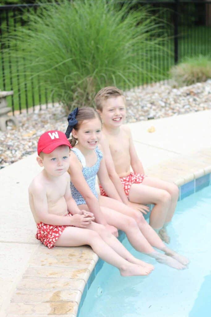 Three kids in swimming pool on a patio