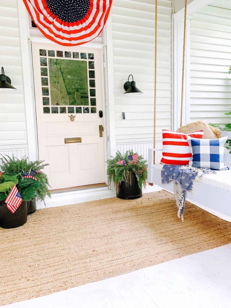 Front porch concrete patio with 4th of July decor and porch swing