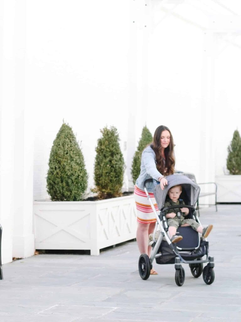 Best bags for mom offer hands free convience to push a stroller as seen with this mom and baby.