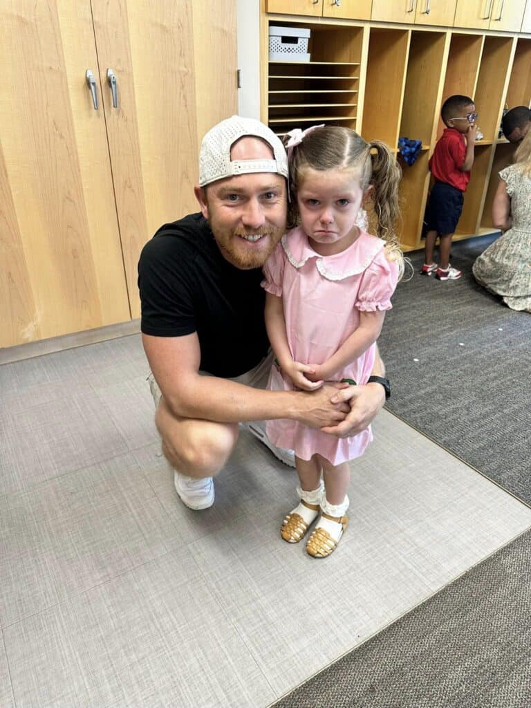 Dad and sad little girl in pink dress.