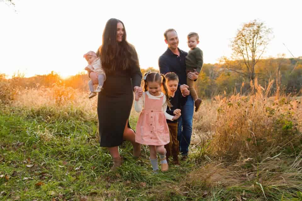 Mom and dad with four kids in fall colors at sunset