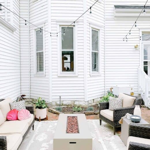 12 tips on where to put a fire pit in your backyard as seen on this patio surrounded by chairs.