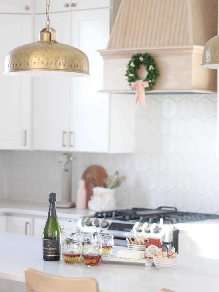 Christmas kitchen with festive holiday decor and brass kitchen pendant lighting hanging over kitchen island.