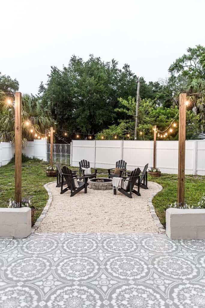 Where to put a fire pit in your back yard doesn't need to be a difficult question. Carve out space in the backyard with this fire pit surrounded by chairs and lights.