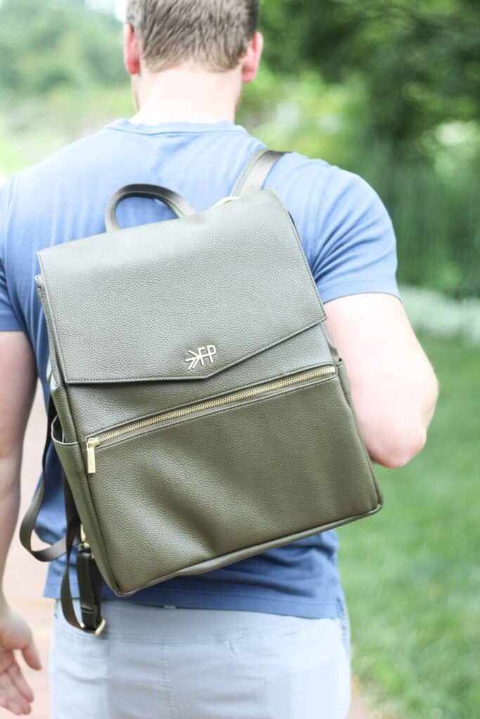 Dad carries a  green backpack diaper bag that works as best bags for moms and dads