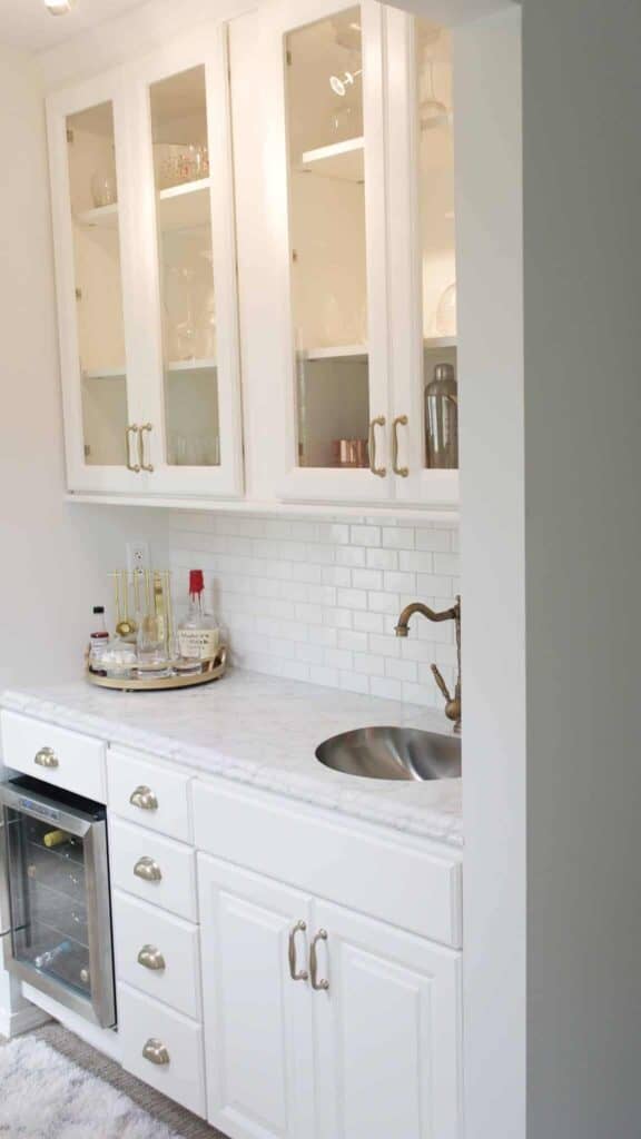 Wet bar with white cabinets and countertop ice maker