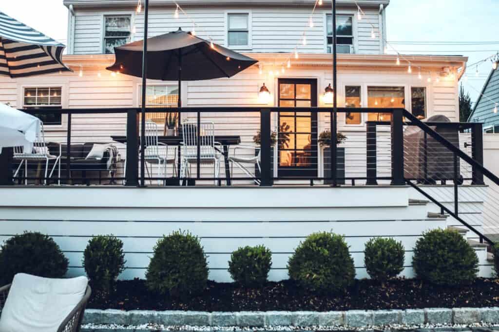 A beautiful deck with backyard patio steps leads to an even more beautiful pool area.