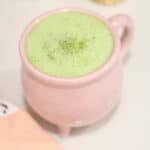 Halloween Coffee Recipes include a wicked matcha tea in a pink cauldron mug.