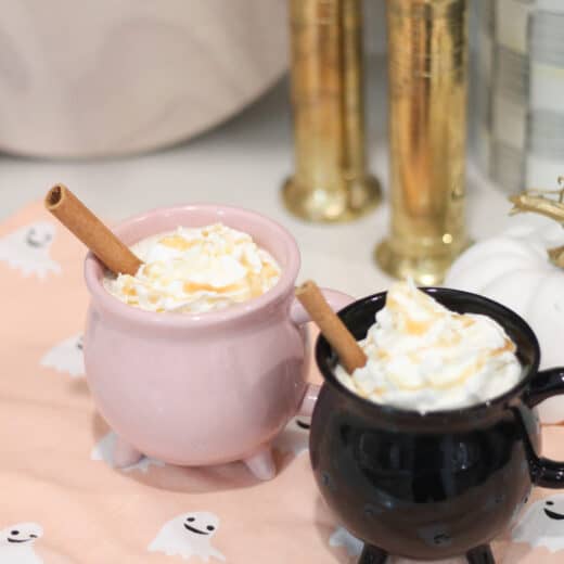 Halloween Coffee Recipes with Witches Brew salted caramel apple cider in pink and black cauldron mugs.