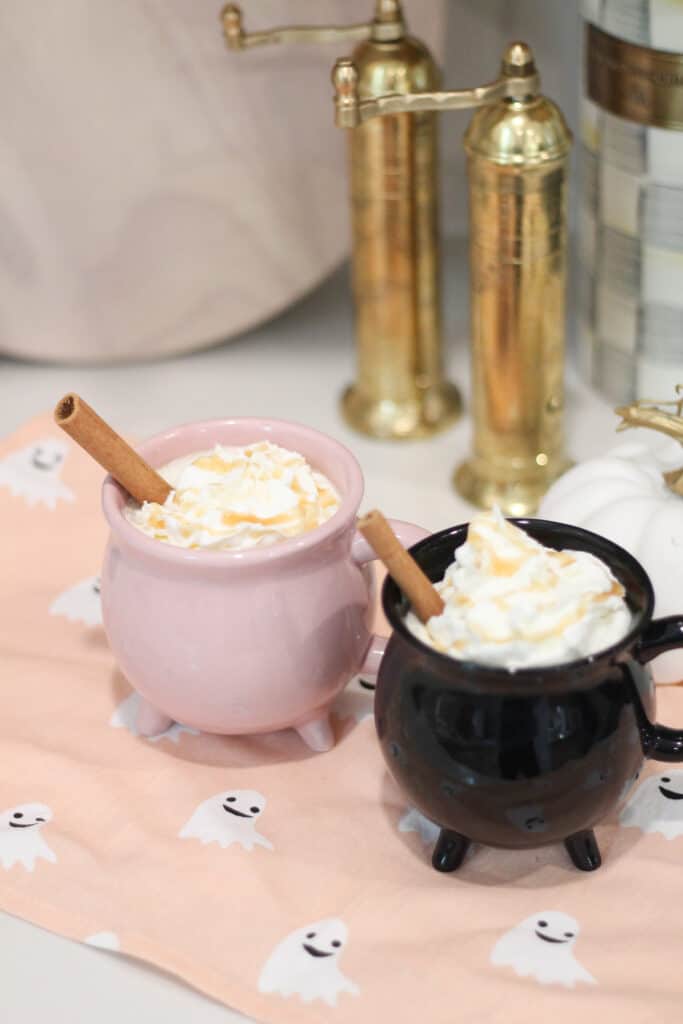 Halloween Coffee Recipes with Witches Brew salted caramel apple cider in pink and black cauldron mugs.