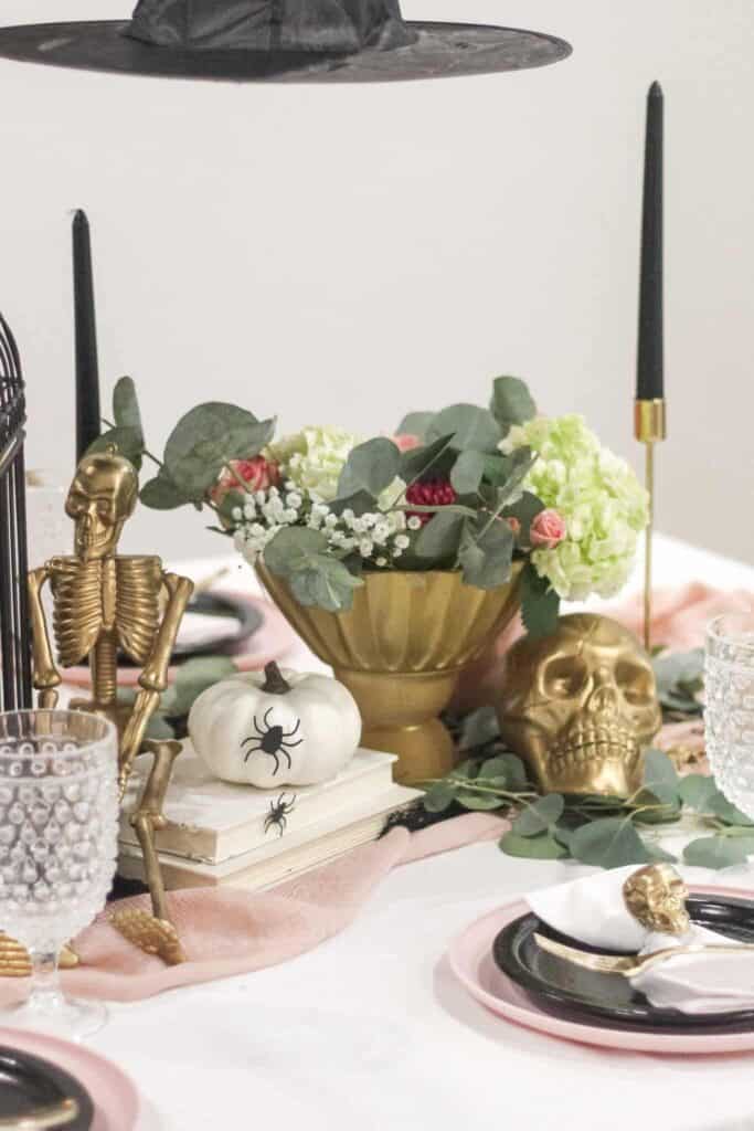 DIY Halloween decorations with gold skulls, white pumpkins, and spiders.