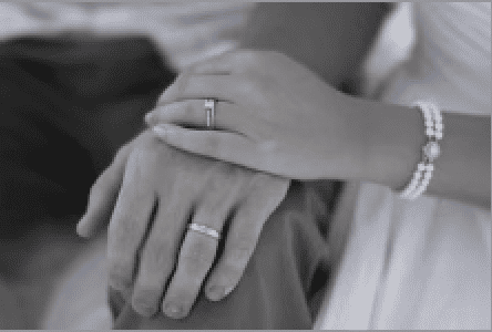 Husband and Wife with bride wearing pearls on her wedding day.