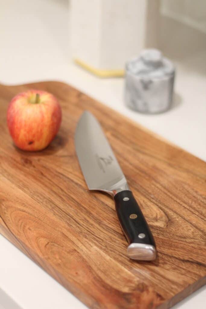 The best Damascus kitchen knife set with apple and cutting board on kitchen counter