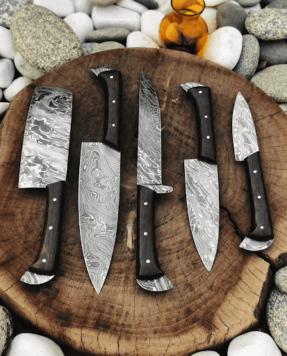 Damascus chef knife set on wooden log