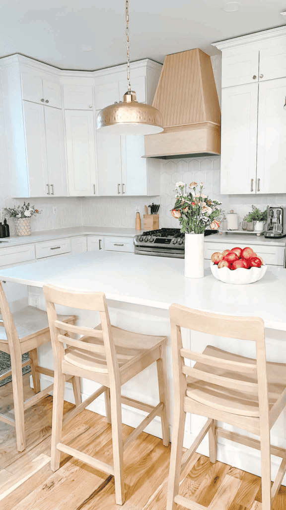 White kitchen island with bowl of apples