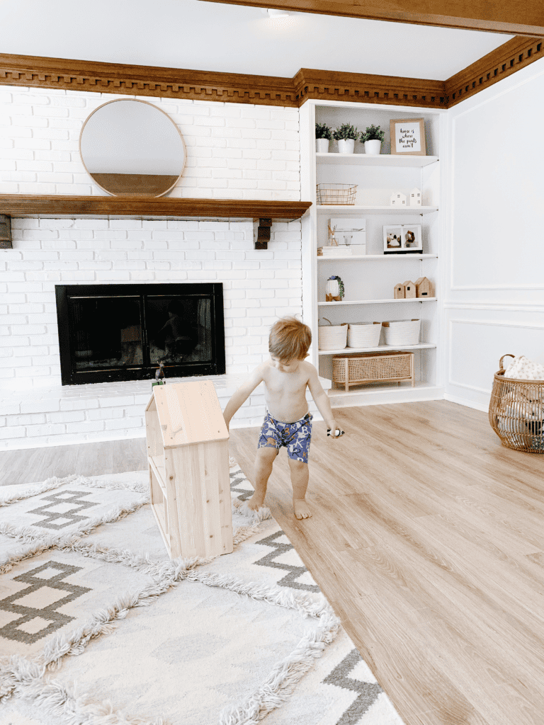 Little boy and wooden dollhouse
