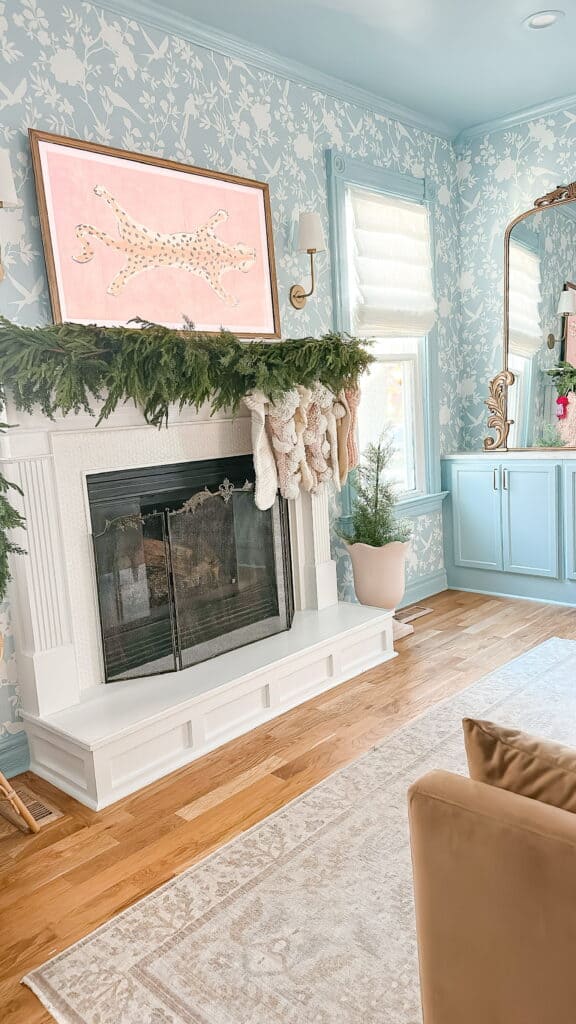 Fireplace with green garland and knitted stockings
