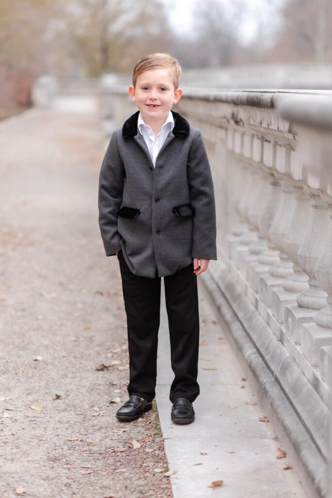 Family Photoshoot Outfit Ideas To Wear In Winter young boy in overcoat