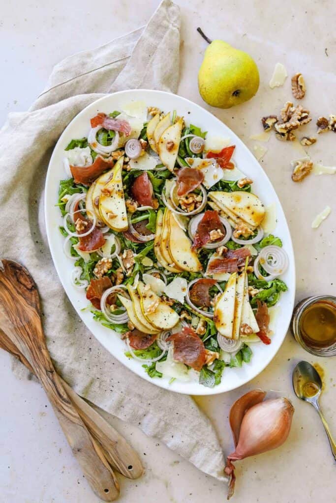 Pear and proscuitto salad with wooden utensils
