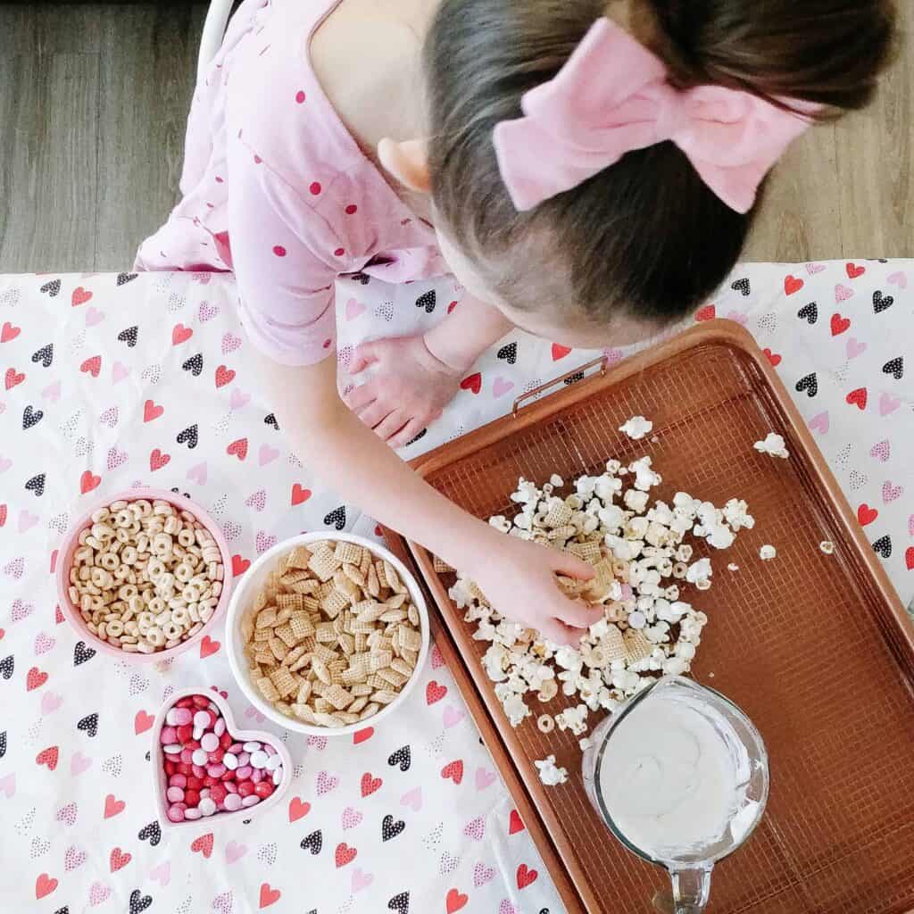 Little girl making popcorn valentines day treat