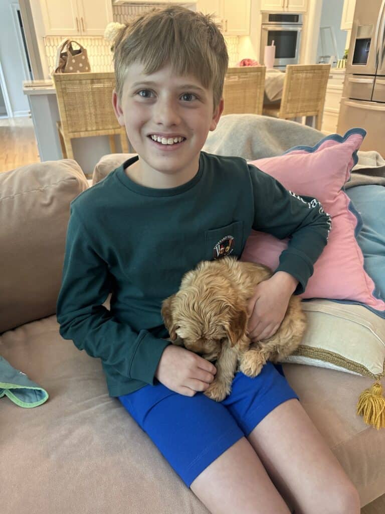 Boy with goldendoodle puppy